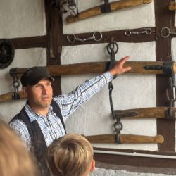 Schmiedemeister Mike Riegert zeigt den Kindern die Werkzeuge und Geräte, die früher auf einem Hof täglich genutzt wurden.